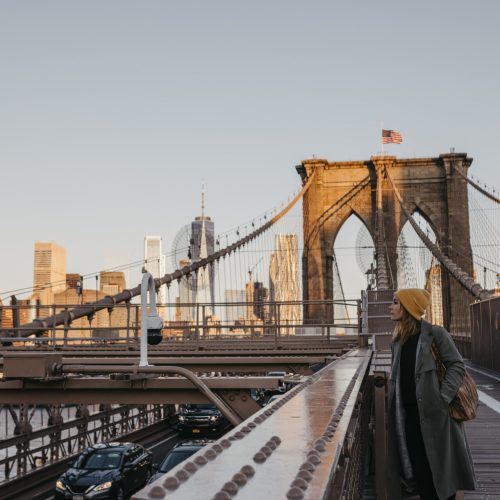 USA, New York, New York City, female tourist on Brooklyn Bridge in the morning light